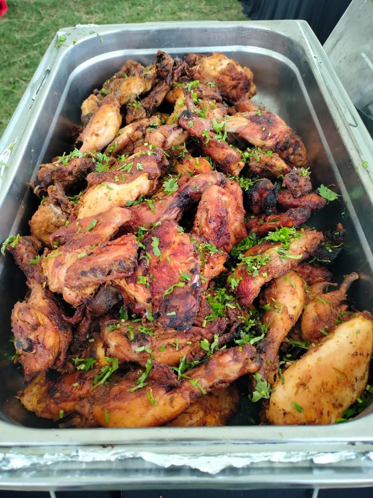 A tray of roasted chicken pieces topped with fresh coriander at Vipe Fun Park