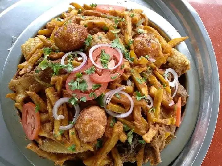 A shared plate of fried potatoes, meat, maize, tomato and onion at Vipe Fun Park