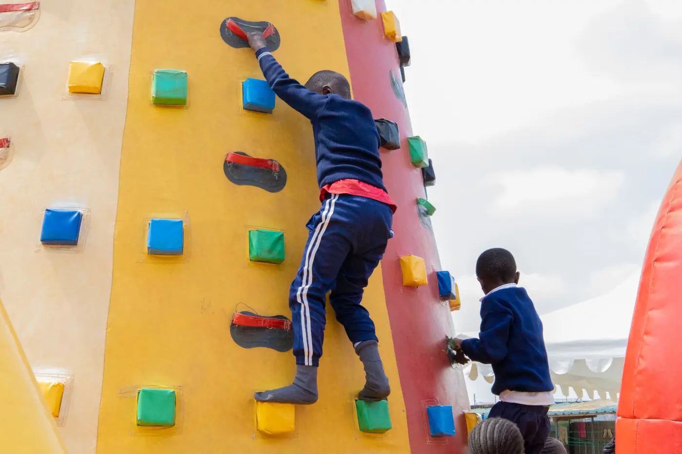 A child photographed from behind climbing the colourful inflatable tower