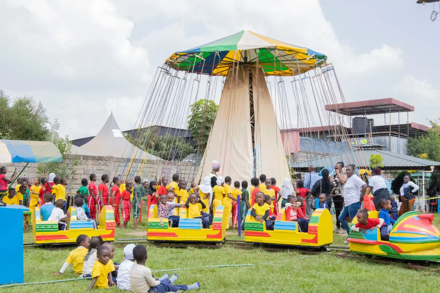 A wide view of the colourful train, chain swing and visiting groups at Vipe Fun Park